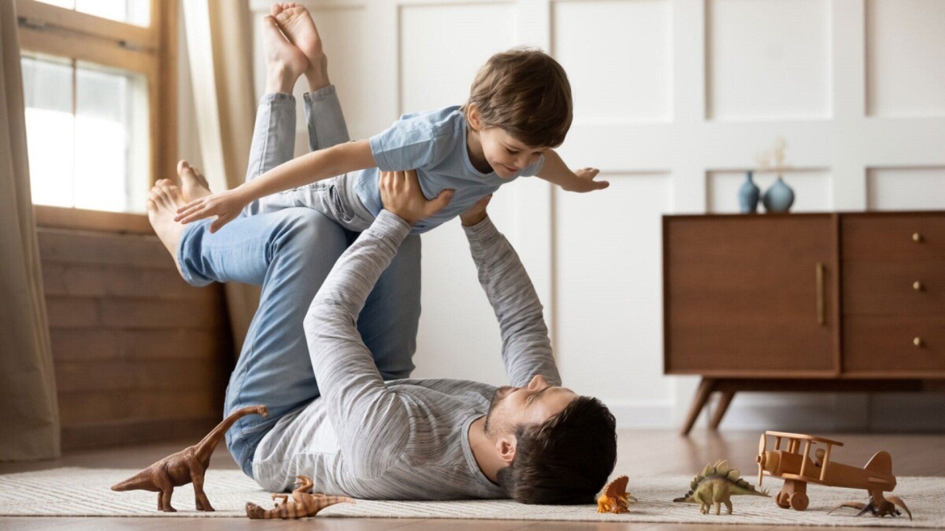 Ein Vater spielt mit seinem Sohn auf dem durch eine Fußbodenheizung gewärmten Boden.