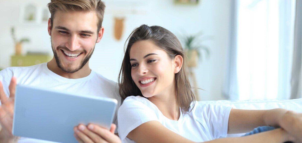 Ein Paar sieht sich den Grundpreis für Strom auf dem Tablet an. 