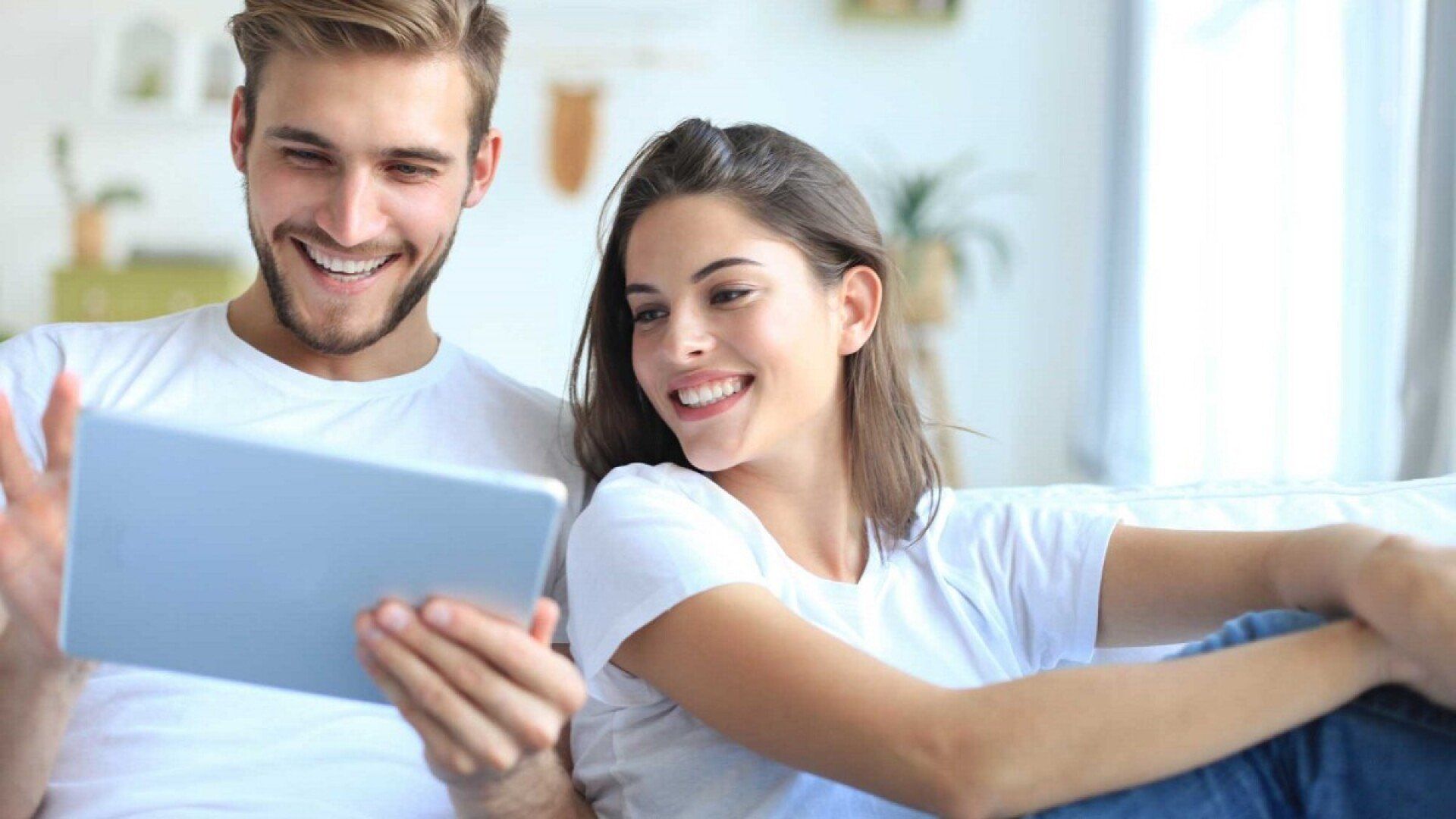 Ein Paar sieht sich den Grundpreis für Strom auf dem Tablet an. 