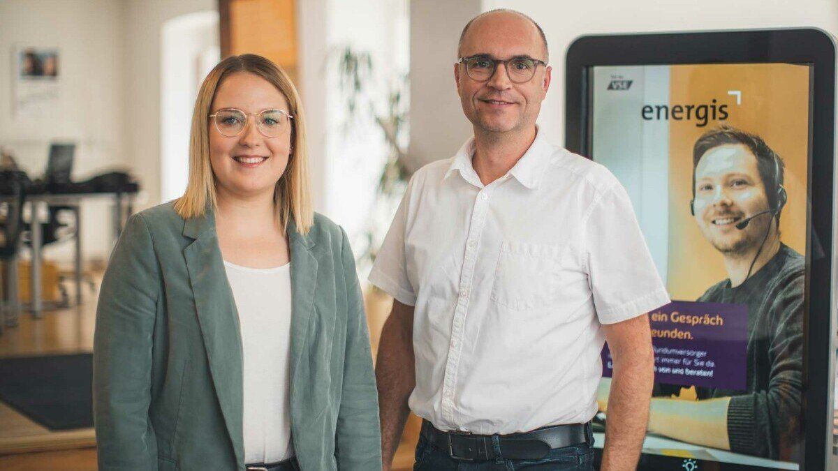 energis Kundenberater im Kundencenter vor Infostele