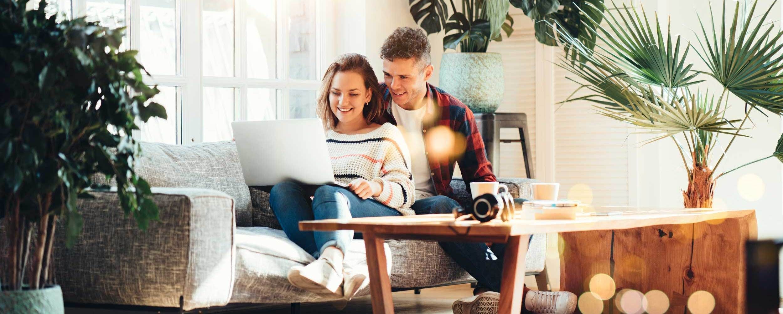 Paar am Laptop im Wohnzimmer