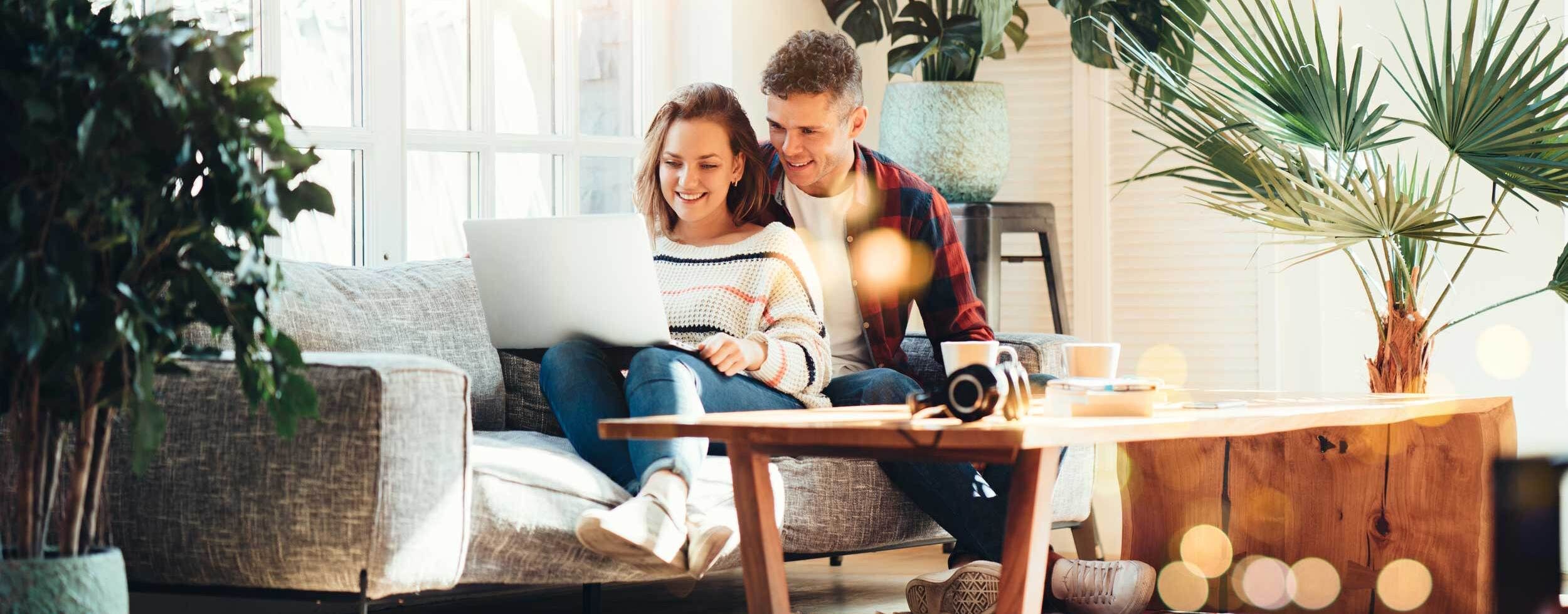 Paar am Laptop im Wohnzimmer