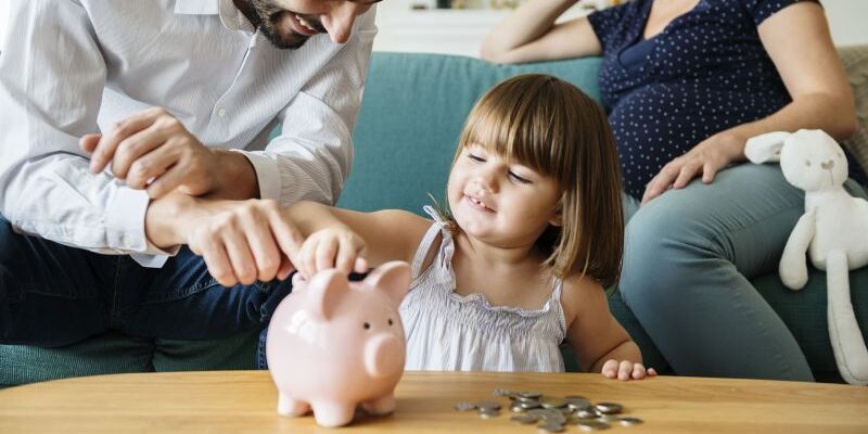 Familie wirft Geld in Sparschwein