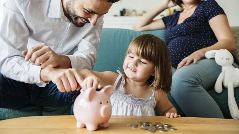 Familie wirft Geld in Sparschwein