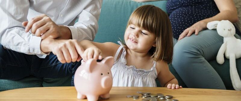 Familie wirft Geld in Sparschwein