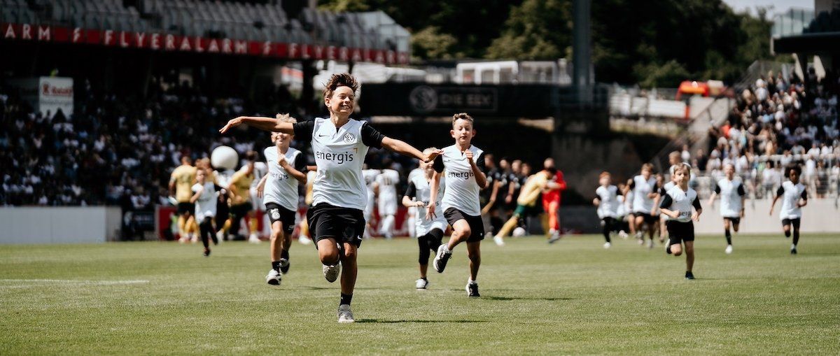 energis Einlauf-Kinder rennend auf dem Fußballfeld des SVE
